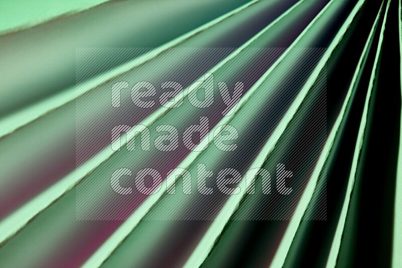 An image presenting an abstract paper pattern of lines in green and pink tones