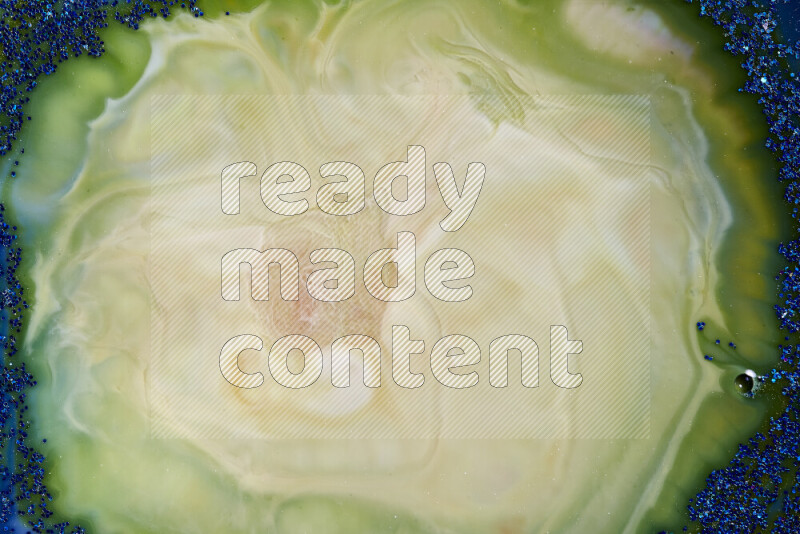 A close-up of sparkling blue glitter scattered on swirling blue and green background