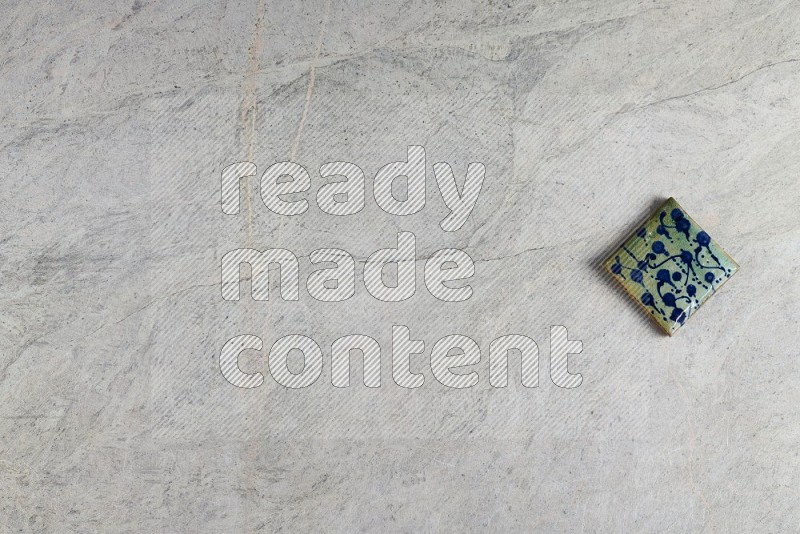 Top View Shot Of A Pottery Coaster tile On Grey Marble Flooring