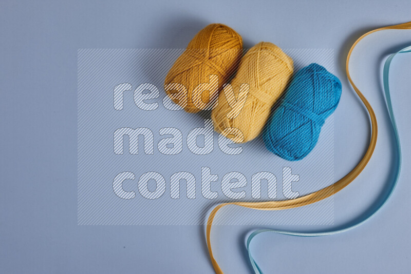A yellow and blue collection of sewing and tailoring tools arranged on a blue background