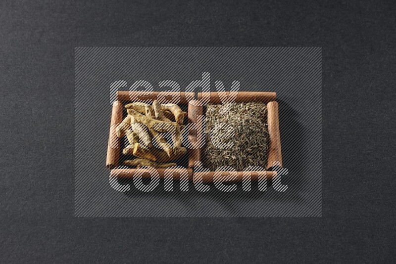 2 squares of cinnamon sticks full of cumin and turmeric fingers on black flooring
