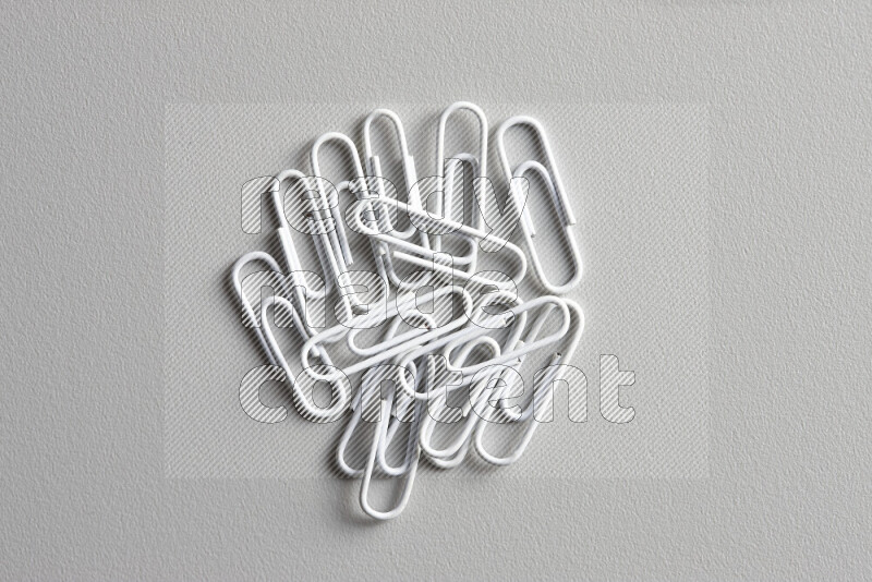 White paper clips isolated on a grey background