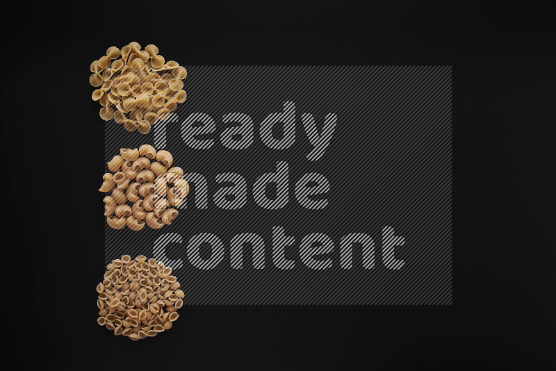 Different pasta types in 3 bunches on black background