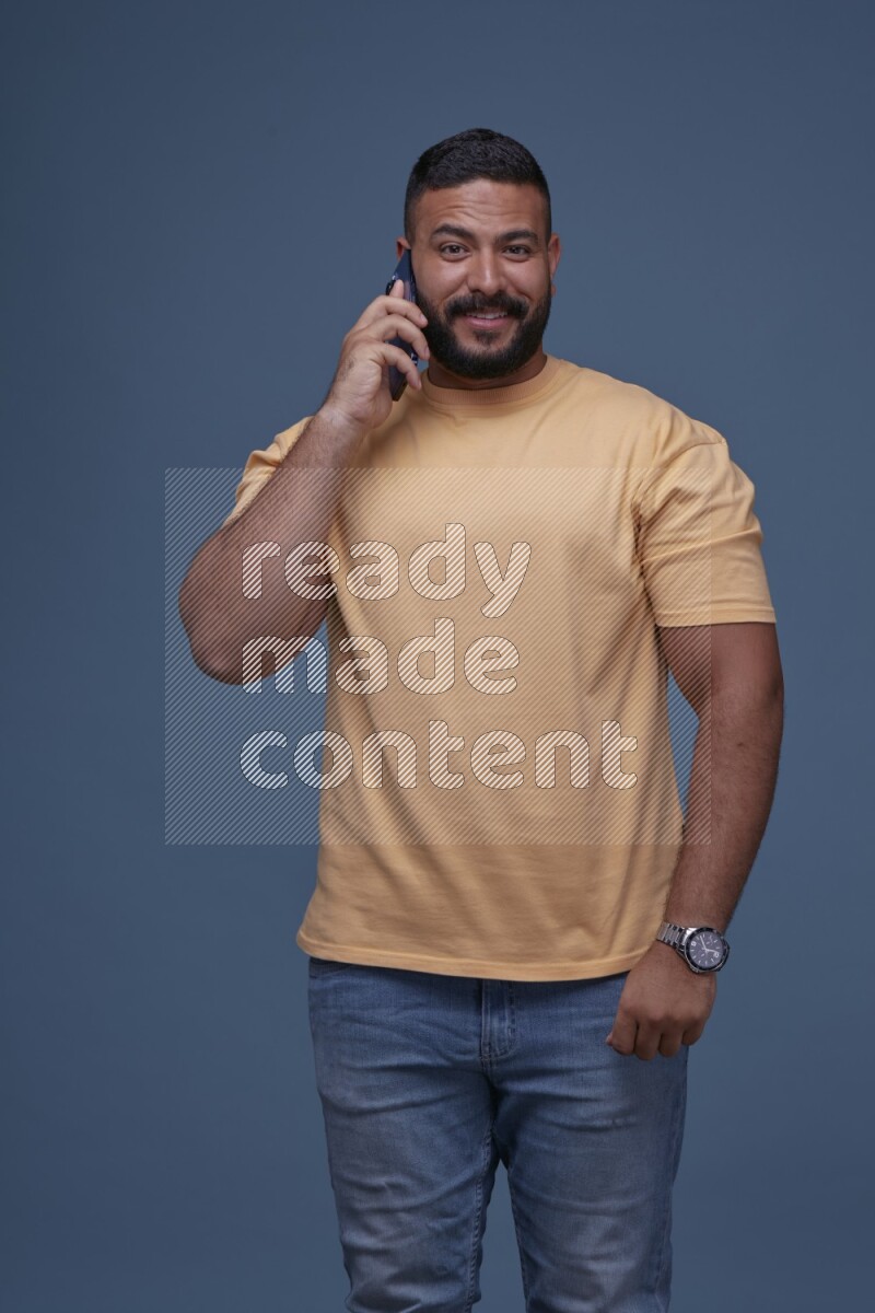 A man Calling on Blue Background wearing Orange T-shirt