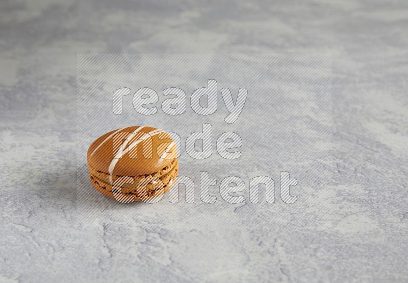 45º Shot of Brown Irish Cream macaron on white marble background