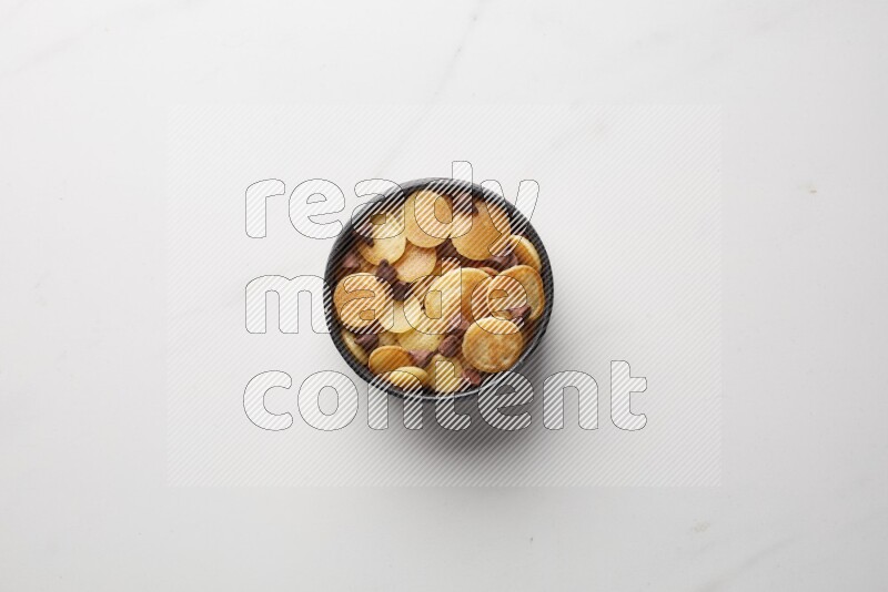 Top-view shot of chocolate chips cereal pancakes in a round bowl on white background