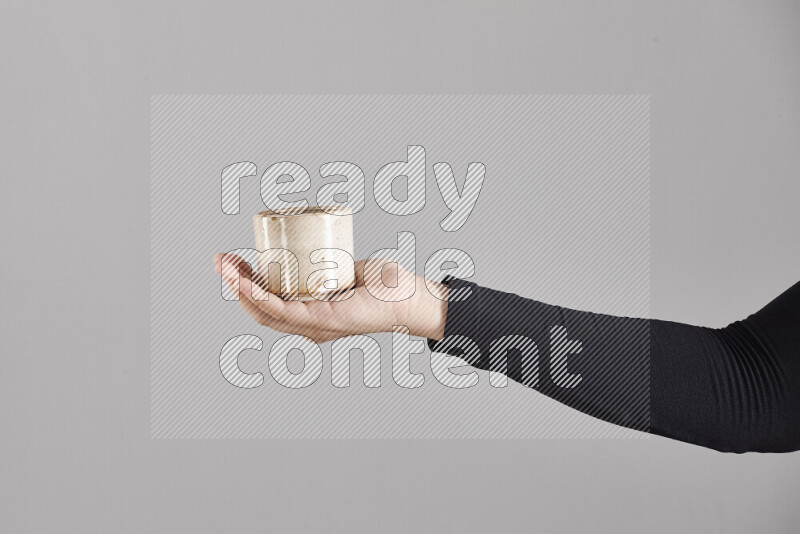 A woman in black abaya holding different pottery essentials in different positions