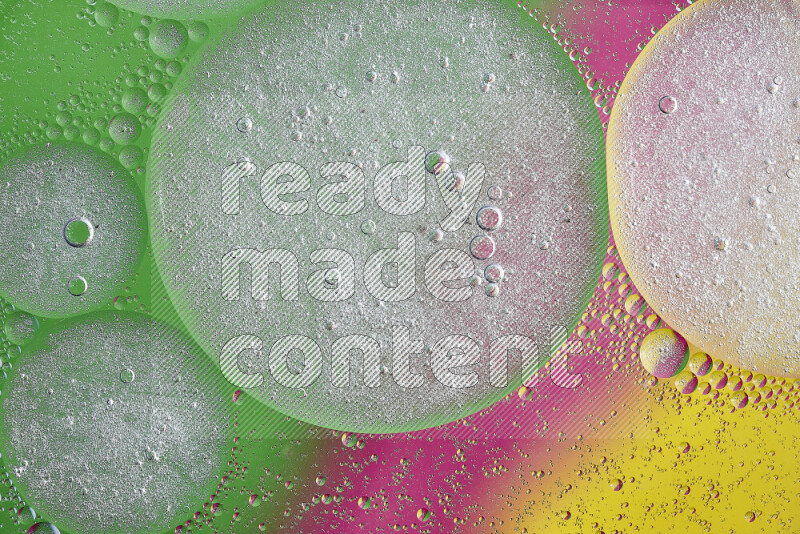 لقطات مقربة لفقاعات من الزيت على سطح الماء باللون الأصفر والأخضر والوردي