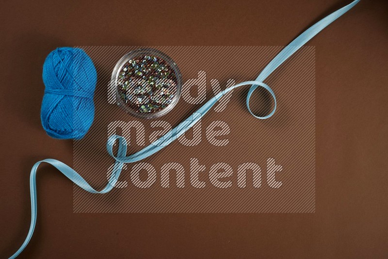 Blue sewing supplies on brown background