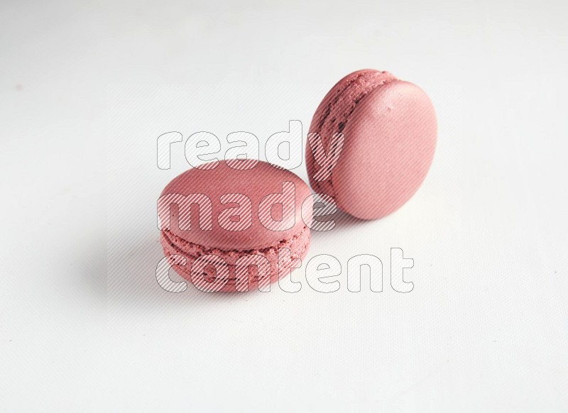 45º Shot of two Pink Raspberry macarons on white background