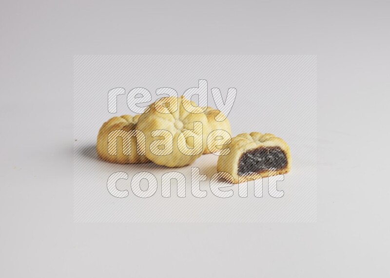 Four Pieces of Maamoul filled with date one of them is cut direct on white background