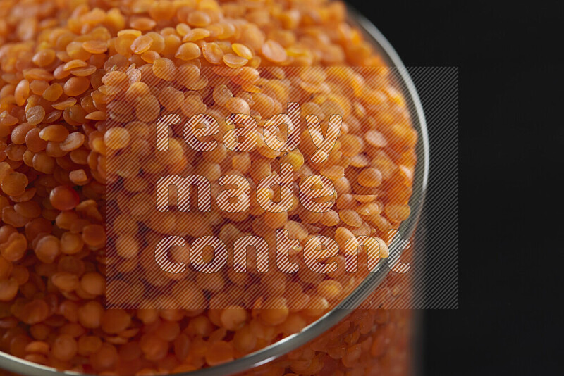 Lentils in a glass jar on black background