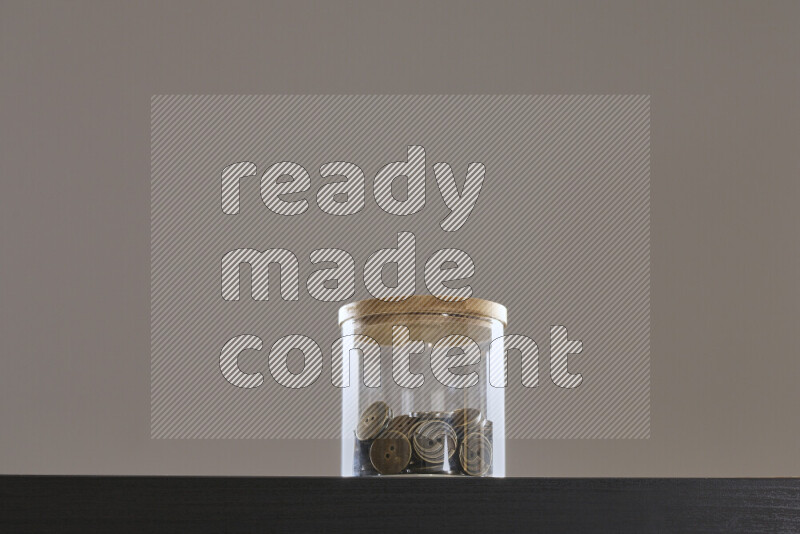 أزرار متنوعة في وعاء زجاجي علي خلفية سوداء