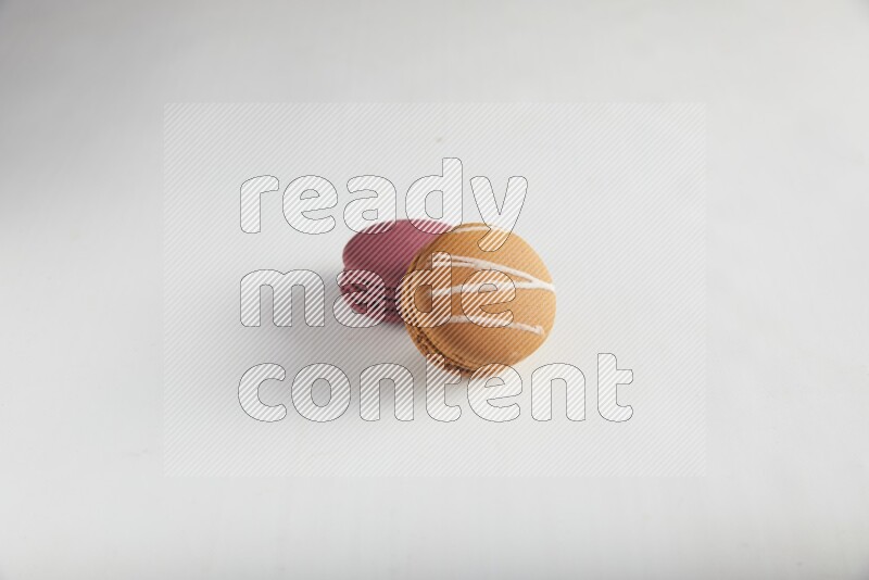45º Shot of of two assorted Brown Irish Cream, and Red Cherry macarons on white background