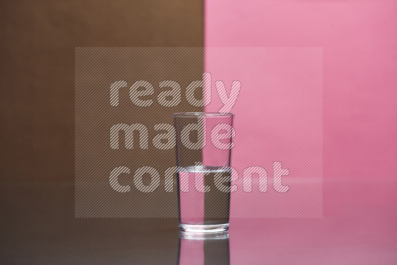 The image features a clear glassware filled with water, set against brown and pink background