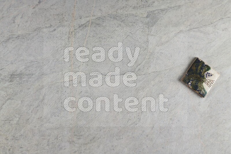 A decorative pottery coaster on grey marble background