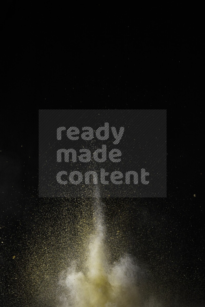 A side view of yellow powder explosion on black background