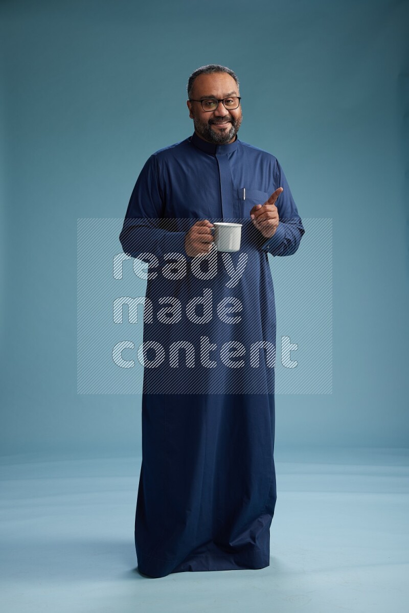 Saudi Man without shimag Standing drinking coffee on blue background