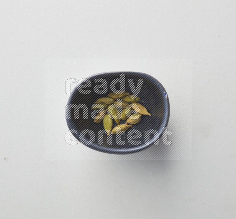 Top-view shot of Cardamon in a container on white background