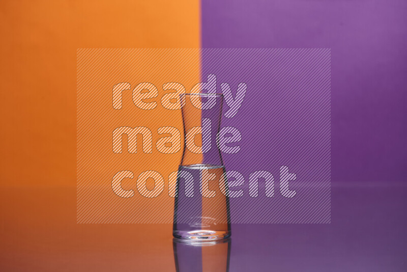 The image features a clear glassware filled with water, set against orange and purple background