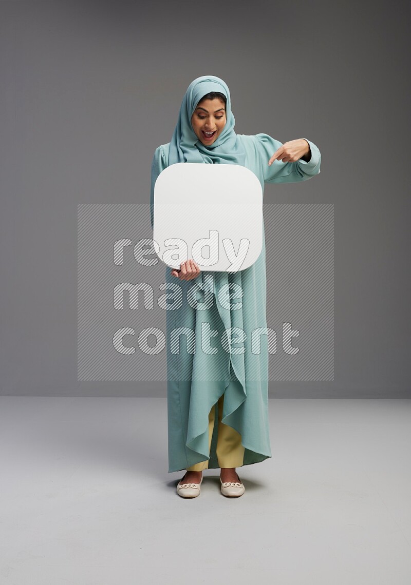 Saudi Woman wearing Abaya standing holding social media sign on Gray background