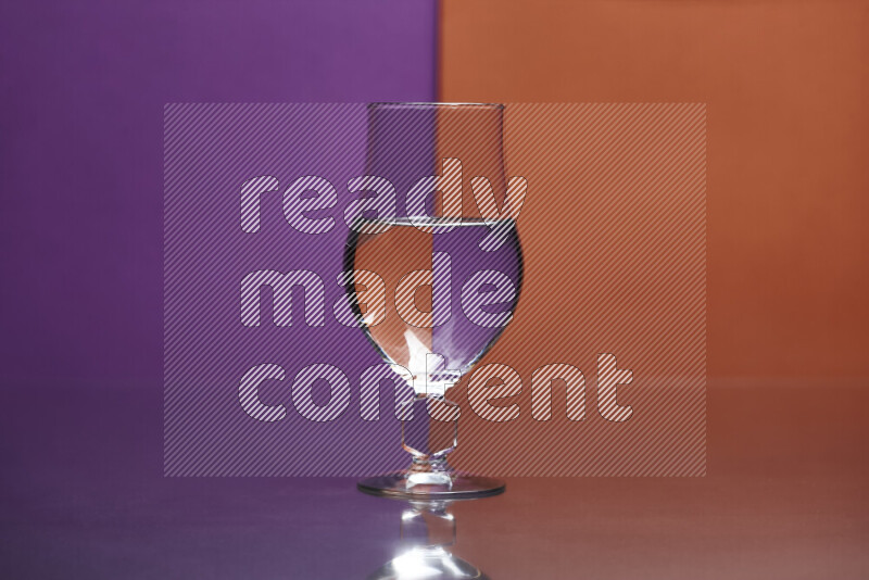 The image features a clear glassware filled with water, set against purple and dark orange background