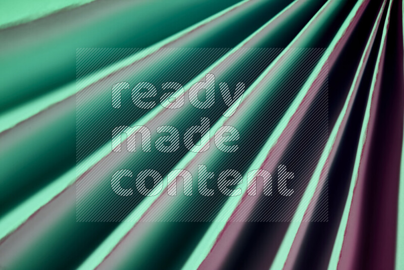 An image presenting an abstract paper pattern of lines in green and pink tones