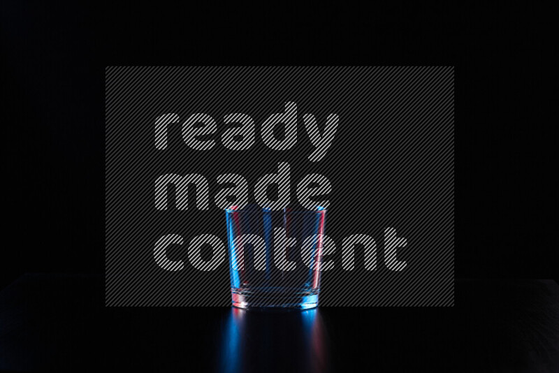 Glassware with rim light in red and blue against black background