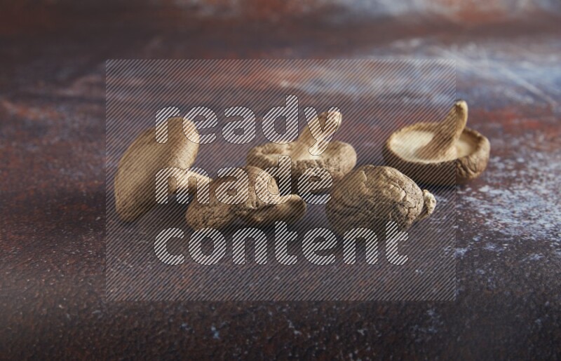 45 degre shiitake mushrooms on a textured reddish rustic metal background