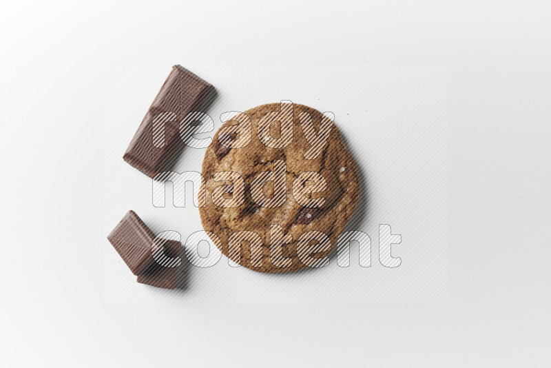 A single chocolate chips cookie with chocolate beside it on a white background