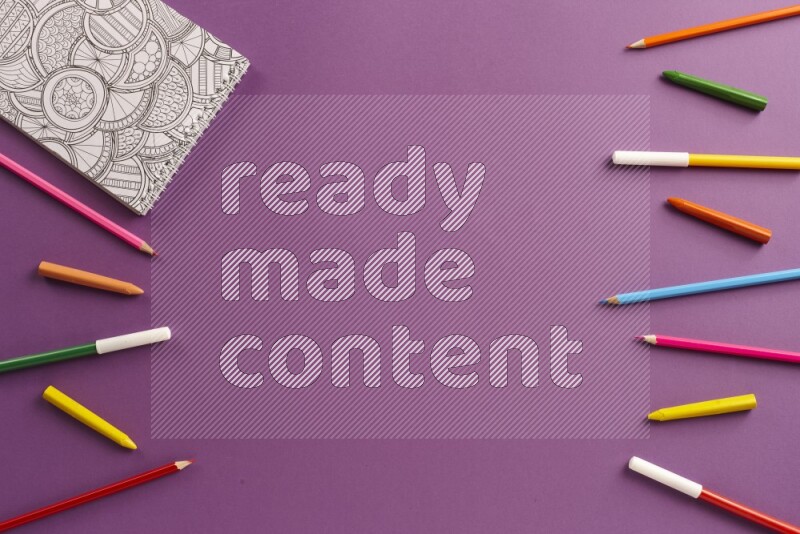 كتاب تلوين مع بعض أقلام التلوين على خلفية أرجوانية