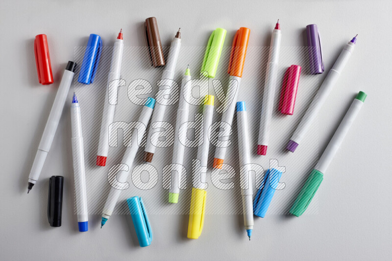 An arrangement of coloring pens in different colors on grey background
