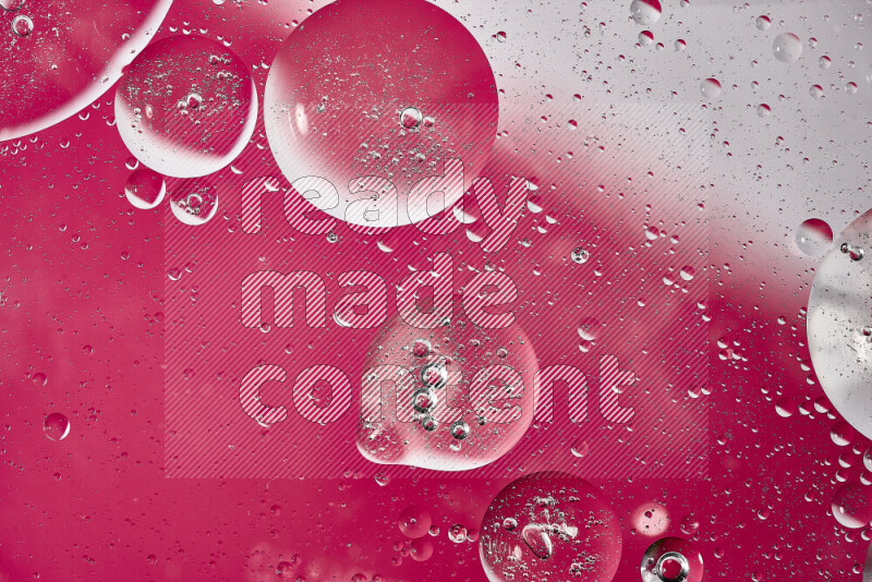 لقطات مقربة لفقاعات من الزيت على سطح الماء باللون الأبيض والوردي