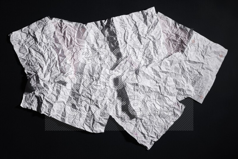 Crumpled notebook sheet on black background