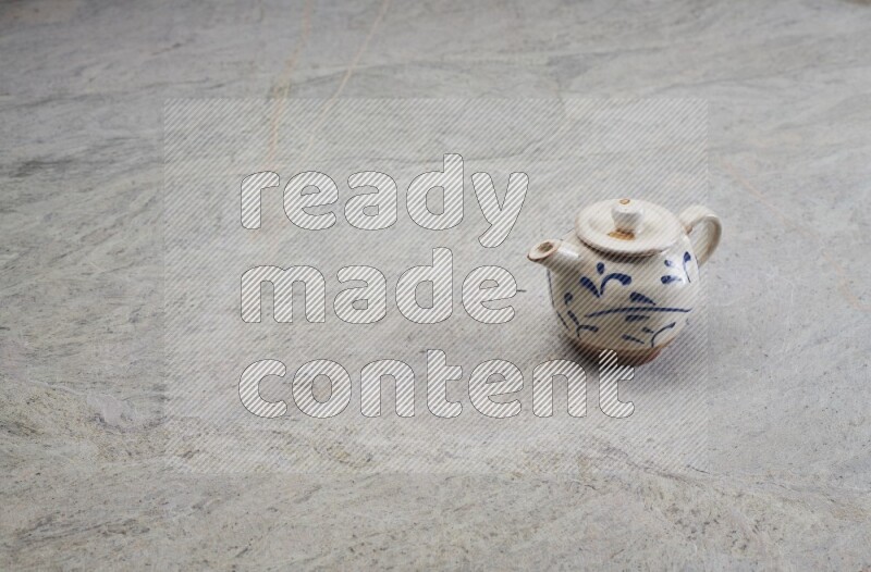 A pottery teapot on grey marble background