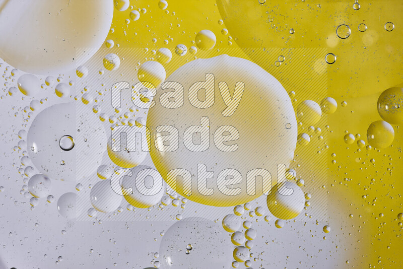 Close-ups of abstract oil bubbles on water surface in shades of white and yellow