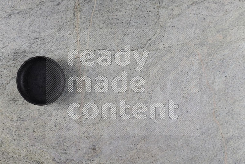 Top View Shot Of A Black Pottery Bowl On Grey Marble Flooring