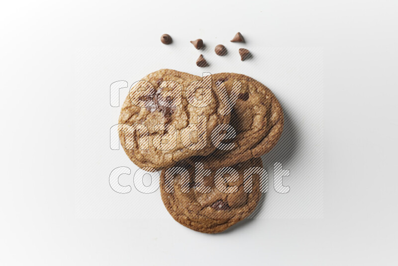 Chocolate chips cookies with chocolate beside it on a white background