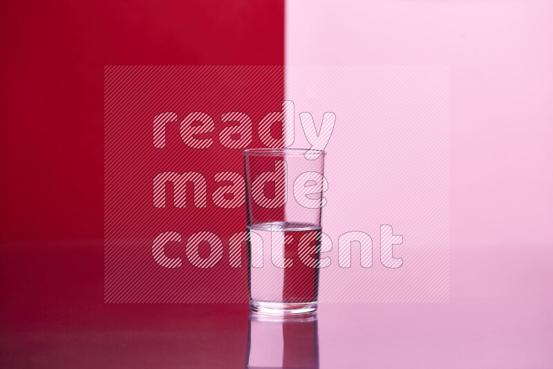 The image features a clear glassware filled with water, set against red and rose background