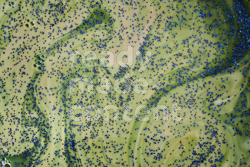 لقطة مقربة لبريق أزرق متلألئ منتشر على خلفية من اللون الأزرق والأخضر في حركات دائرية