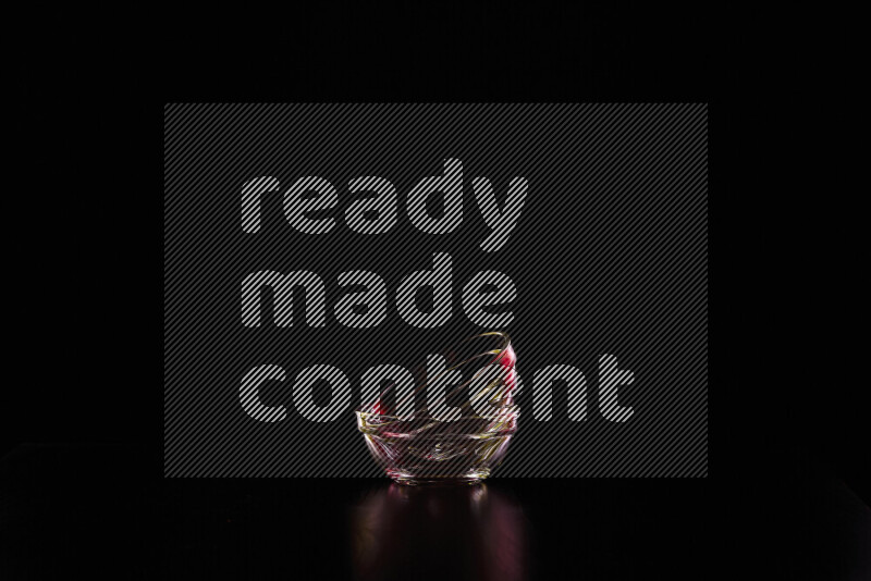 Glassware with rim light in red and yellow against black background