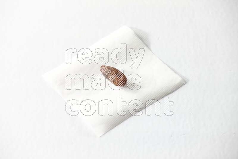 A dried date on a piece of paper on a white background in different angles