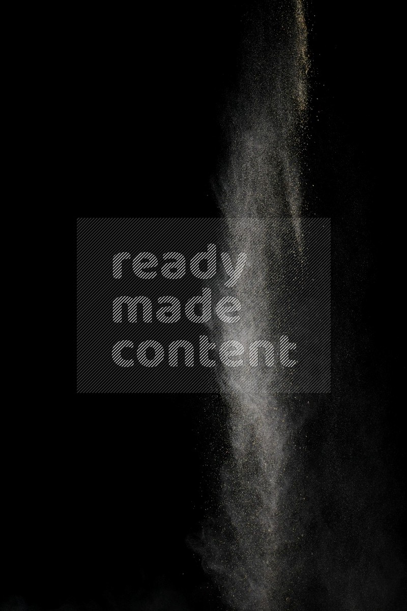A side view of brown powder explosion on black background