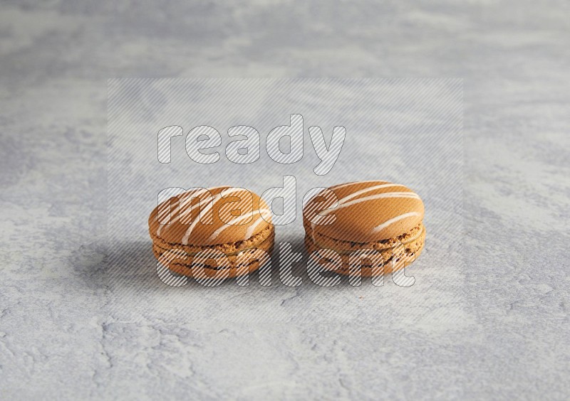 45º Shot of two Brown Irish Cream macarons  on white  marble background