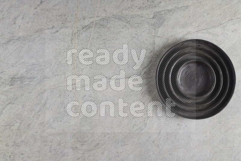 A pottery black ripple plate on grey marble background