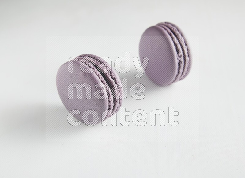 45º Shot of two Purple Blueberry macarons on white background