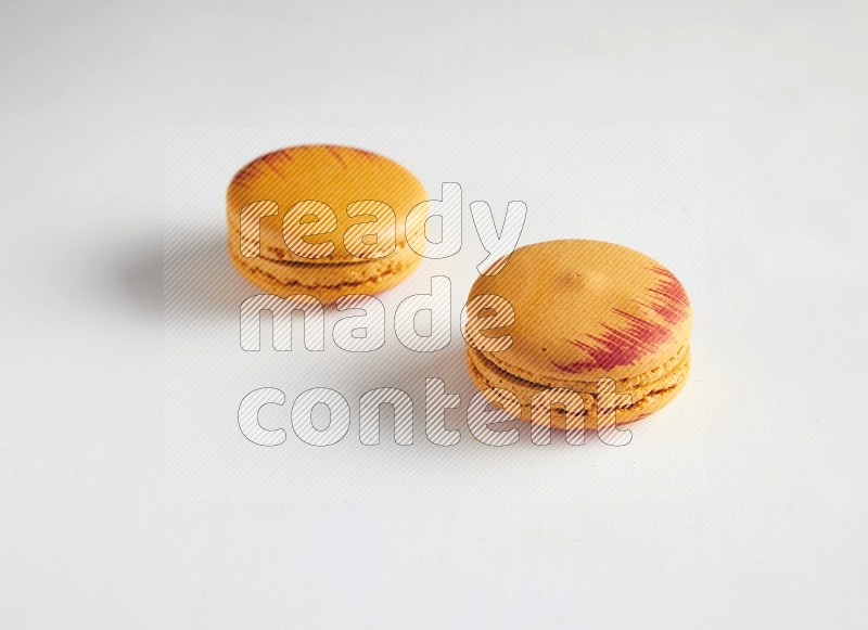 45º Shot of two orange Exotic macarons on white background
