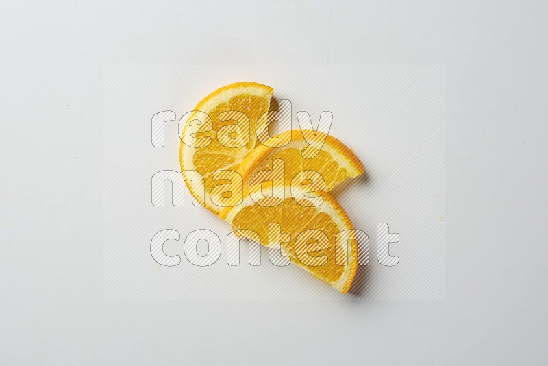 Three halves of an orange slices on white background