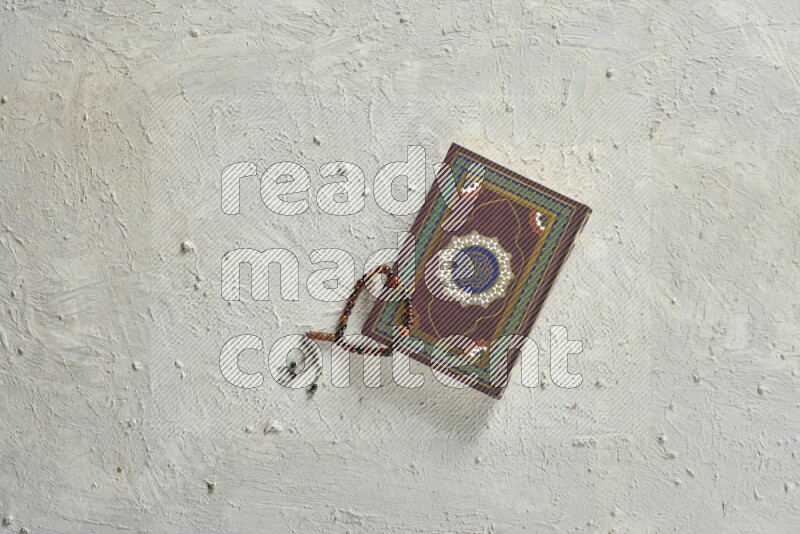 Quran with a prayer beads on white background