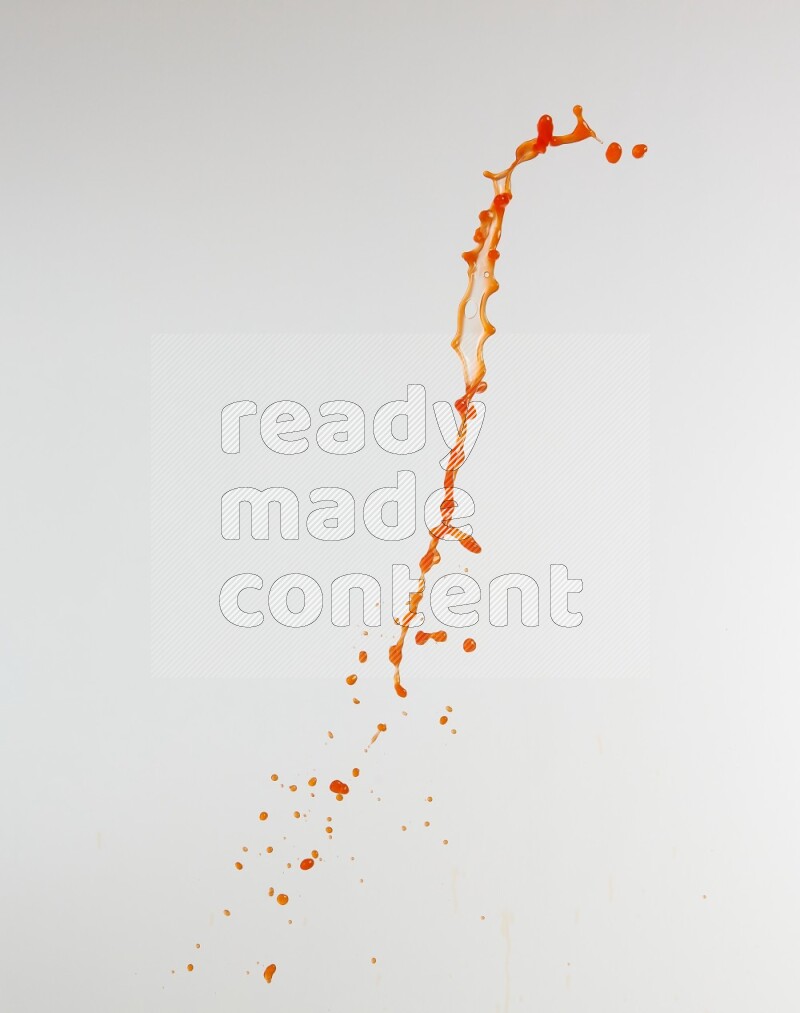 Orange liquid splash and drops on white background